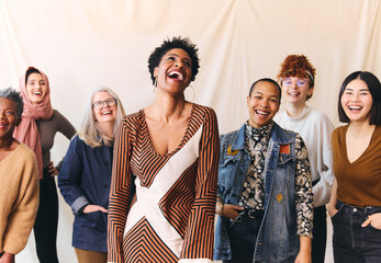 International Women's Day portrait of cheerful multi ethnic mixed age range women laughing and smiling - Powered by Adobe