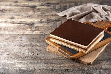 Opera cake dessert slice on wooden table	