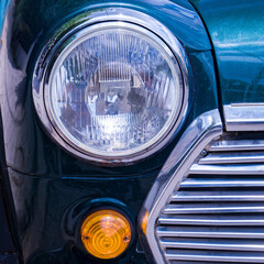 classic car partial front view with head light and chrome grille