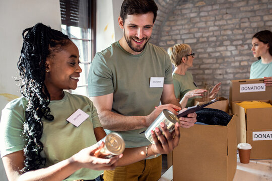 Group of volunteers working in community charity donation center.
