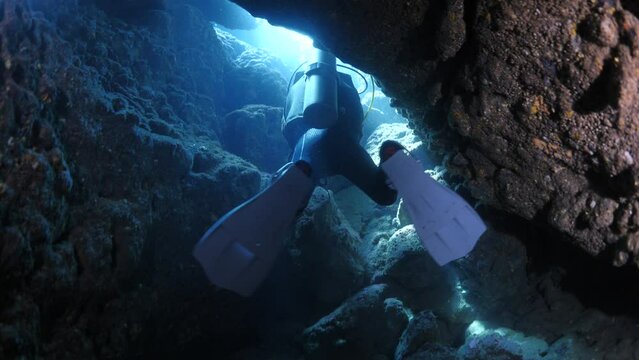cave diving underwater scuba divers exploring caves ocean scenery	