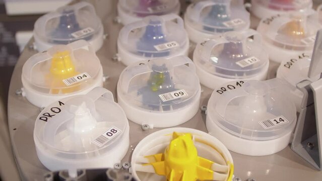 Automatic dispenser. Top view of the pigment paste containers. Open tank with yellow paint.
