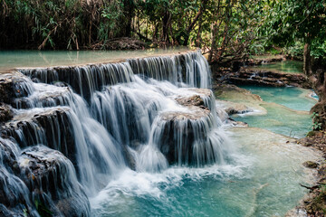 Amazing turquoise water of Kuang Si waterfall in tropical rain forest. Laos