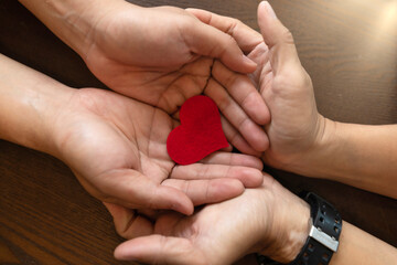 Hands of Couple holding Red Heart Symbol