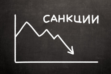 The word "Sanctions" in Russian next to a financial graph of a falling stock market. Concept on the financial, economic and political crisis in the world due to the outbreak of the war.