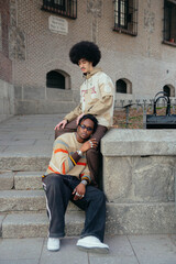 Black gay couple sitting on stairs.