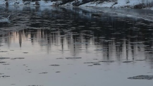 Ice floats, moves along the river, ice drift, winter landscape, river in the forest