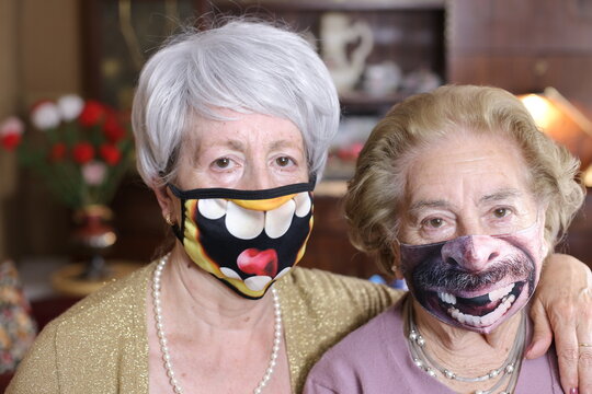 Senior Female Friends Wearing Hilarious Protective Masks