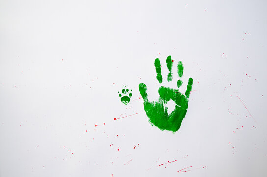 No war text with handprint and dog's paw print on white background,soft focus. Green handprint of human and dog's paw print with red drops
