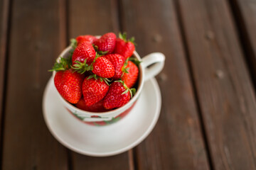 MUG OF FRESH STRAWBERRY ON WOODEN TABLE