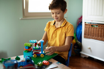 Adorable boy playing with toys at home. Little child playing with lots of toys indoor.