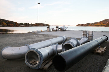 Metal pipes lay on the ground of small cargo port