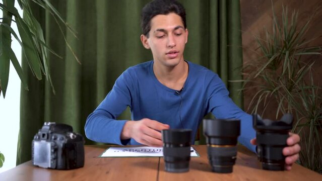 Cheerful arab teacher photographer talking to webcam on conference call. coach, tutor looks at the camera during the webinar talks about aperture values and their designation. webcam view.