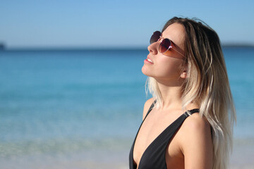 close up portrait of young woman in bikini and sunglasses on beach in Australia