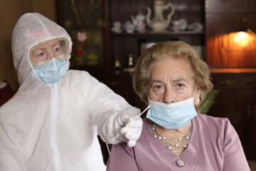Protected nurse getting nasal sample with cotton swab