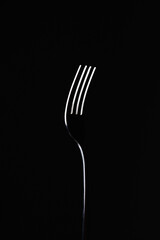 fork on black background. abstract minimalist composition. art object - obrazy, fototapety, plakaty