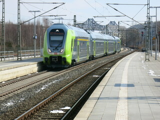 Zug am Bahnsteig und vor der Rendsburger Hochbrücke