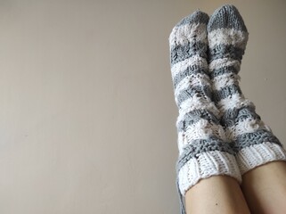 legs in grey and white striped knitted socks