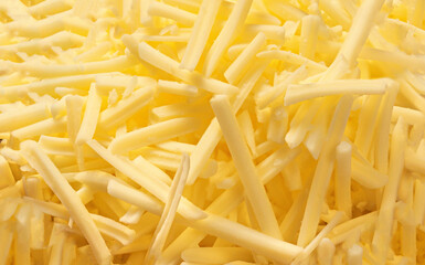 Grated cheese for sandwiches as a background, top view. Cutted cheese closeup. Pattern.