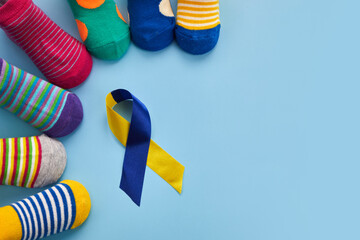World Down syndrome day background. Down syndrome awareness concept. Socks and ribbon on blue...