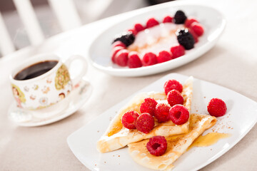 breakfast of pancakes with fresh raspberries on table