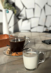 Glass mug of milk and americano coffee with dark sugar in cafe - 489204995