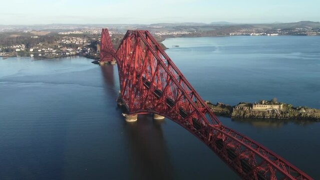 Aerial view of the Forth Rail Bridge with Inchgarvie in the background. Circling right to left around the bridge with zoom in.