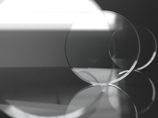 three glass lenses on a reflective surface before black background with focus on second lens. 3D rendering.