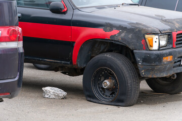Flat tire in an old rusty car. Car repair after an accident and being on the street for a long time