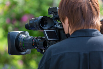 Video camera operator working with his equipment. video cinema production. Covering an event with a...