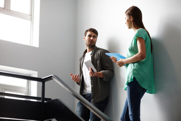 Fototapeta premium Sharing ideas informally. Shot of two people having a conversation in a stairwell.
