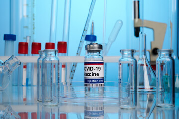 Russian vaccine vial on a chemical lab desk. Coronavirus immunization remedy among flasks and test-tubes. Blue color tones. Chemical expertize of covid-19 inoculation. Science research of antivirus.