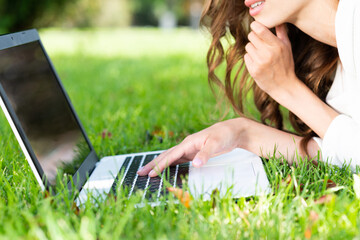 young woman and laptop in the park