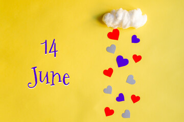 14 june day of month, colorful hearts rain from a white cotton cloud on a yellow background. Valentine's day, love and wedding concept