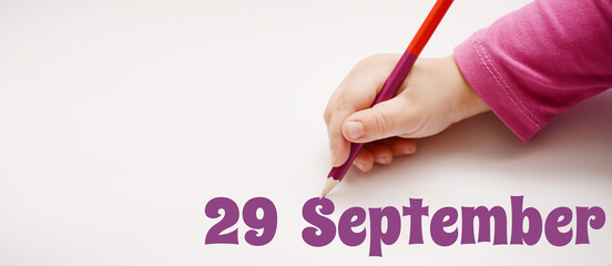 A child's hand writes 29 september in a lilac pencil. Banner with copy space