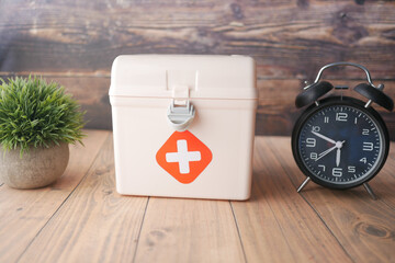  first aid kit box and a clock on table 