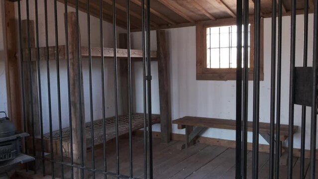 Old west jail cell with bars and beds