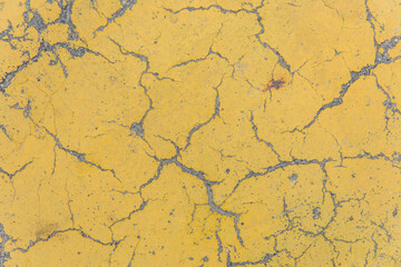 Cracks on yellow paint concrete surface cracked weathered cement worn texture broken abstract damaged pattern background