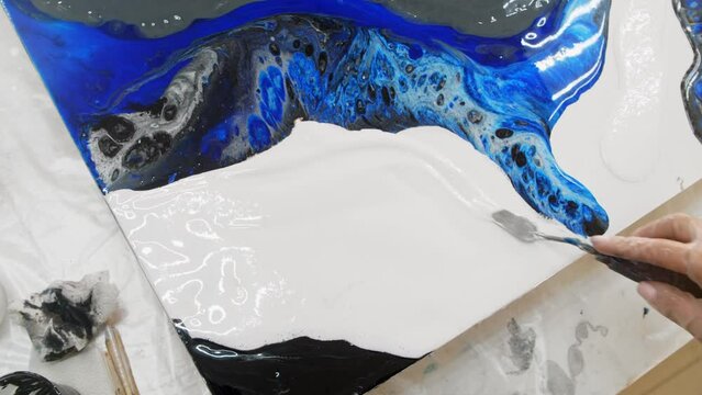 Drawing a painting with white epoxy resin using a spatula