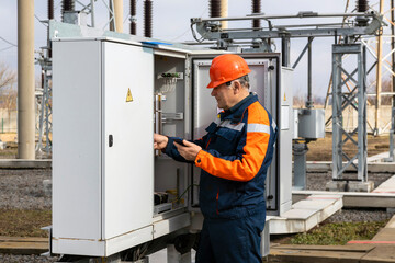 Power engineer inspects substation equipment. Energy. Industry.