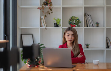 Portrait of beautiful young asian woman working on laptop in workplace.