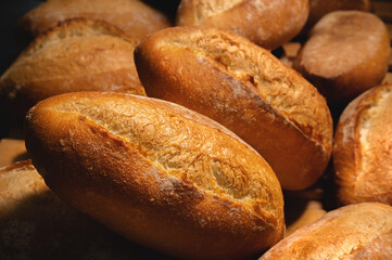 Sourdough bread close-up. Freshly baked round bread with golden crust on bakery shelves. The context of a German bakery with a rustic assortment of bread.
