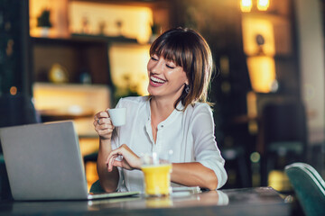 Beautiful attractive woman at the cafe with a laptop having a coffee break