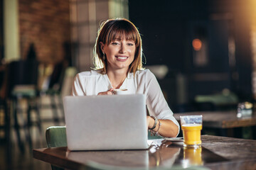 Beautiful attractive woman at the cafe with a laptop having a coffee break