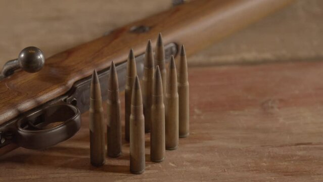 Dolly in of 8mm cartridges in front of WW2 era Mauser K98