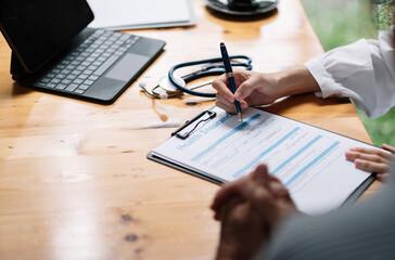 Female health insurance broker presenting his insurance benefits to businessman fill out insurance policy. To prevent future incidents.