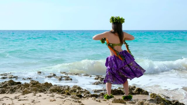 Beautiful hawaiian woman performing hawaiian dance happily barefoot on the beach