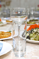 Empty wine glasses, a shot glass and a glass on the festive table with dishes.
