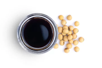 Foto op Canvas Soy sauce in glass bowl with soybeans isolated on white background. Top view. Flat lay. © NIKCOA