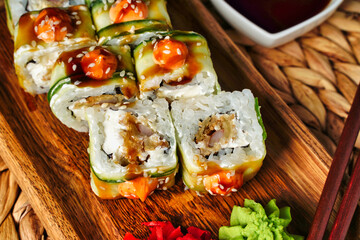 Japanese rolls with shrimp wrapped in cucumber with spicy sauce sushi close up